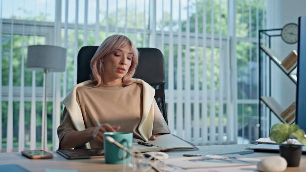 istock Tired director closing notebook taking break in coworking workplace closeup 2201162472
