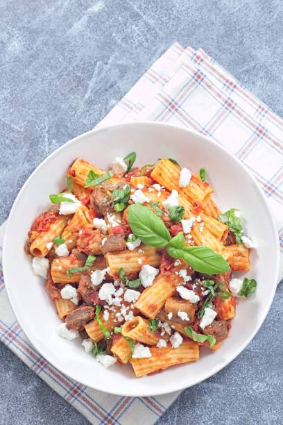 istock Rigatoni alla Norma pasta with eggplant, tomato, basil, ricotta salata, vertical, top, copy space 2201162679