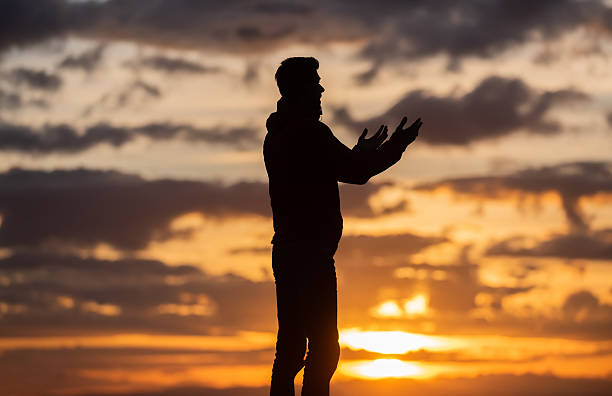 Silhouette of prayer having worship and praying with hands open at sunset Silhouette of muslim woman prayer having worship and praying with hands open doing dua to Allah at sunset . High quality photo i love allah in arabic silhouettes stock pictures, royalty-free photos & images