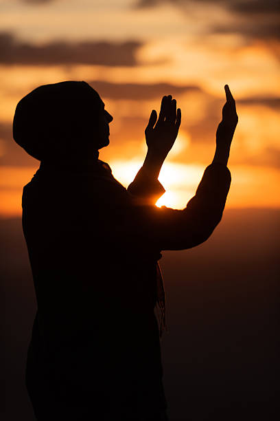 istock Muslim woman prayer praying with hands up open doing dua worship Allah. 2201164610