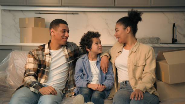 Happy joyful parents mom dad little child boy kid son together on couch relocation moving day smiling African American family home owners relax on sofa buy rent house real estate mortgage bank credit Happy joyful parents mom dad little child boy kid son together on couch relocation moving day smiling African American family home owners relax on sofa buy rent house real estate mortgage bank credit. High quality photo mum new boyfriend stock pictures, royalty-free photos & images