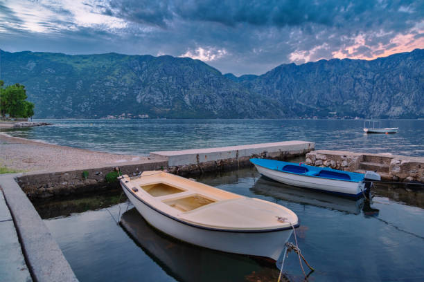 The boats in the sea at sunset with mountains in the background. The Bay of Kotor. Montenegro.