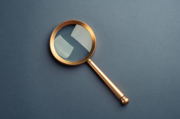 Magnifying glass on a gray background. Vintage. FAQ. Curiosity, inquiry, uncertainty. Search for answers, clarity, and understanding. Quest for knowledge or solutions. Solving mysteries