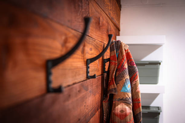 istock A wooden wall with three hooks on it and a coat 2201177844