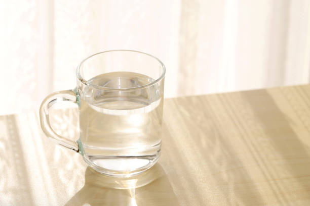 istock glass cup of water on a wooden table 2201178247