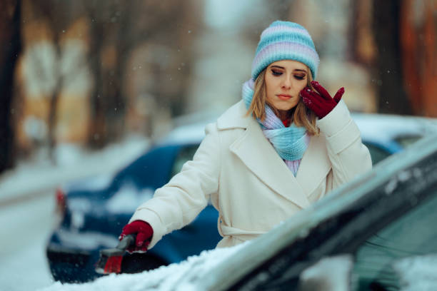 istock Serious Woman Uses Brushing the Snow from a Car 2201191233