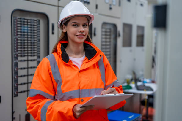istock Female electrical engineer inspects electrical system at equipment control cabinet High voltage transformers in distribution substations 2201193881