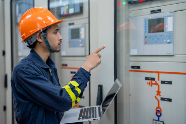 istock technician in orange helmet operates machinery while using laptop, ensuring safety and efficiency in industrial setting 2201193923