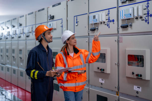 istock Two electrical engineers discussing control panels in power facility, wearing safety gear and helmets, showcasing teamwork and professionalism 2201193937