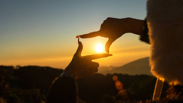 istock Closeup of woman hands making frame gesture capturing sunset, Future planning concept. 2201195781