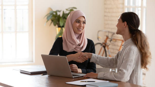 istock Middle eastern ethnicity and mixed-race businesswomen shaking hands 2201213225