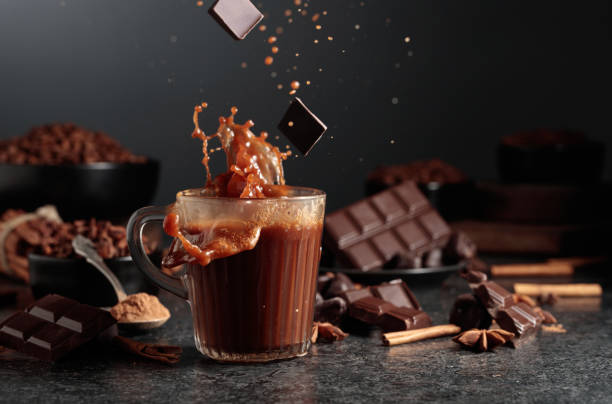 istock Pieces of dark chocolate fall into a mug of cocoa drink. 2201214429
