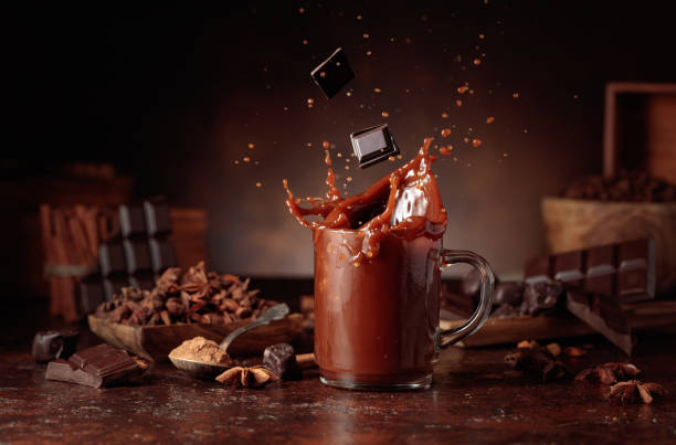 istock Pieces of dark chocolate fall into a glass of cocoa drink. 2201214435