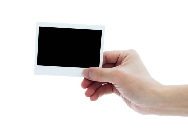 istock Human hand holding blank instant photo card on white background 2201215215