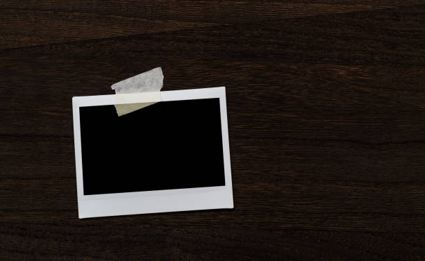 Directly above view of single blank instant photograph on wooden table