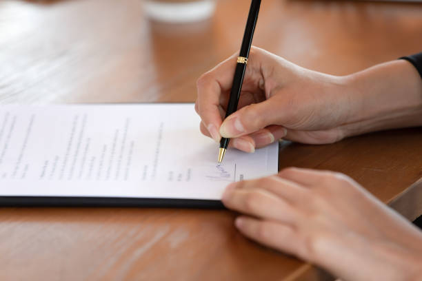 istock Closeup woman job candidate putting signature on document in office 2201220846