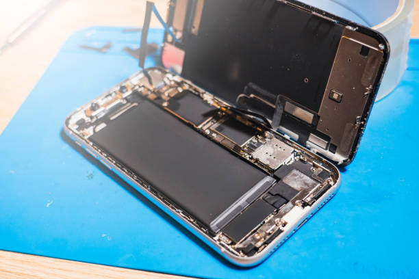 istock Phone repair process showing a disassembled mobile device and its components on a workbench in a tech workshop 2201221174