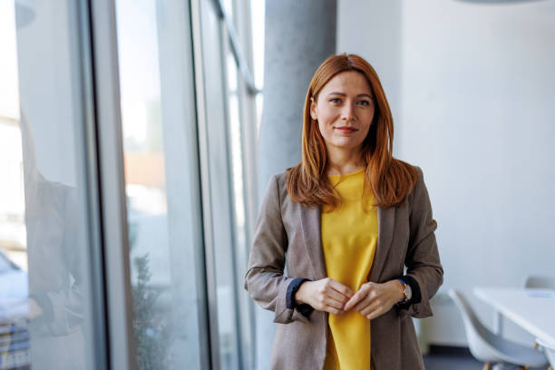 istock Confident businesswoman standing in modern office by the window 2201222155