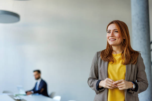 istock Young businesswoman smiling in modern office with copy space 2201222172