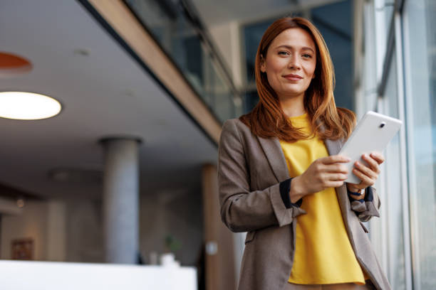 istock Businesswoman using digital tablet in modern office building 2201222188