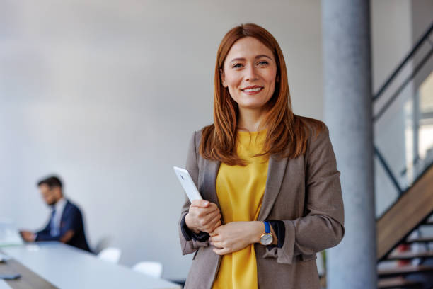 istock Confident businesswoman holding tablet in modern office 2201222200