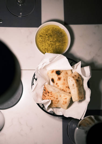 istock Rustic Italian bread served with a bowl of warm soup on a marble table, cozy dining atmosphere in an Italian restaurant, traditional European cuisine concept 2201222563