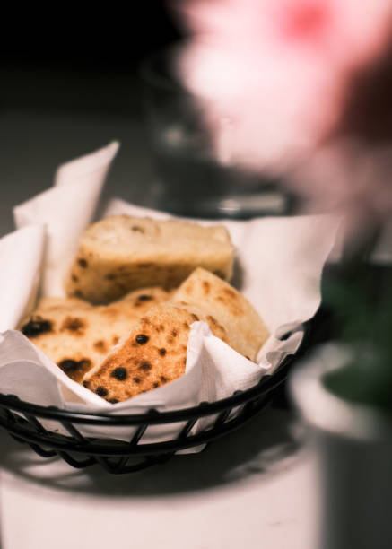istock Freshly baked flatbread served in a basket with parchment paper, Warm and rustic bread with a golden crust and soft texture, Perfect for dipping, appetizers, or side dishes in a restaurant setting 2201222596