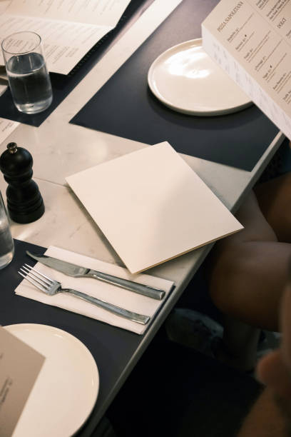 istock Elegant restaurant table setting with blank menu and cutlery on a marble surface, sophisticated dining atmosphere with contemporary design and minimalistic aesthetics 2201223973