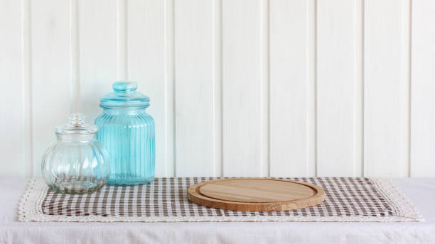 Kitchen containers standing on wooden slice on blue background