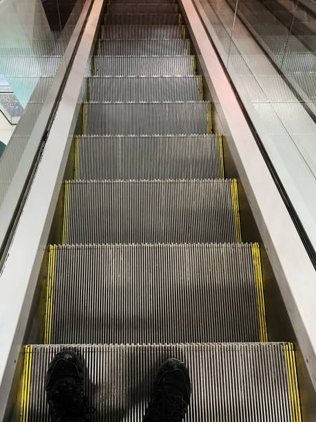 istock View looking down at metal escalator steps with reflective sides in urban setting 2201228235