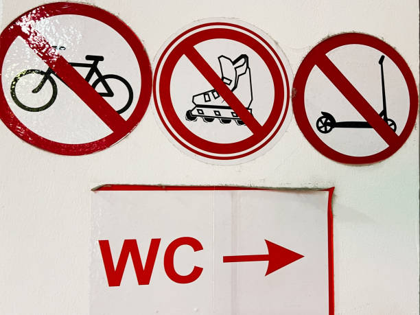 istock Prohibition signs for bicycles, roller boots, scooters, near a restroom direction sign 2201228304