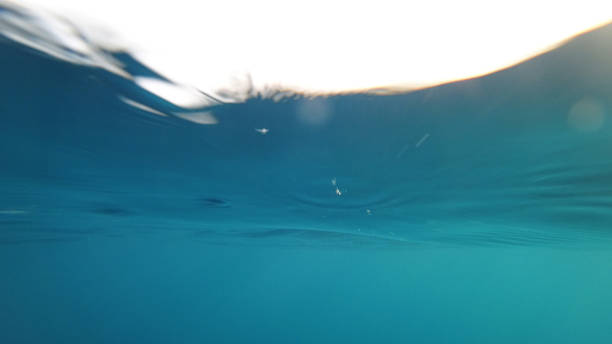 istock Underwater view of the surface with light reflections and ripples 2201235761