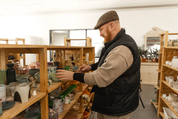 istock Redhead senior man looking through the bargains in a public second hand store 2201241156