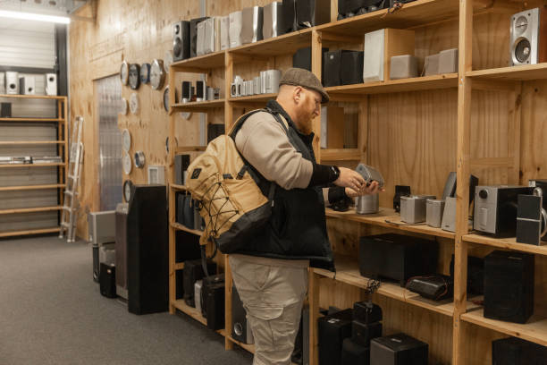 istock Redhead senior man looking through the electronics in a public second hand store 2201241428