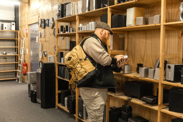 istock Redhead senior man looking through the electronics in a public second hand store 2201241429