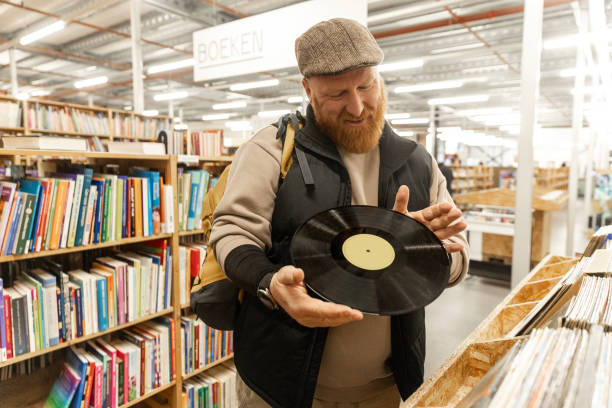 istock Redhead senior man looking through the bargains in a public second hand store 2201242819
