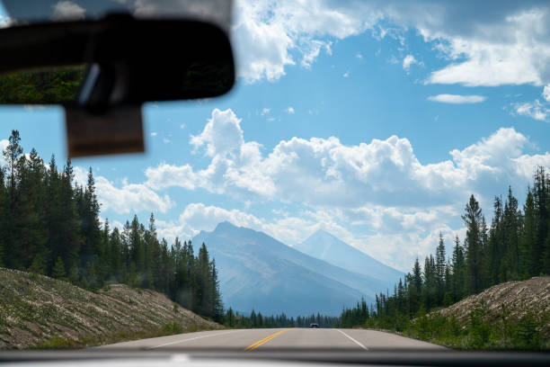 istock Driving through canadian rockies on a sunny day with blue sky and clouds 2201245932