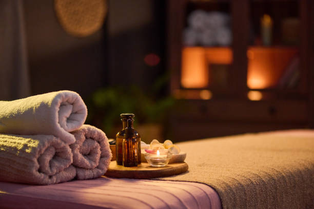 istock Massage Table with Towels Rolls and Jar of Oil 2201246092