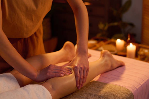 istock Hands of Professional Masseuse Kneading Calf 2201247095