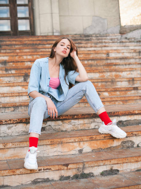 istock Young woman sitting on the old rusty stairs 2201258297