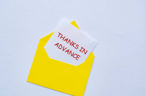 istock Top view of yellow envelope with a white card partially pulled out with text Thanks In Advance 2201263708