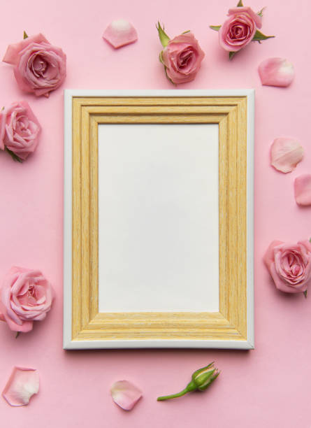 istock Empty frame surrounded by pink roses and petals on pink background 2201268939