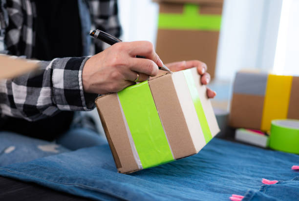 istock Girl Preparing Cardboard Box For Shipping 2201269012