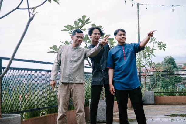 istock Three Southeast Asian men pointing together on a rooftop viewpoint 2201269726