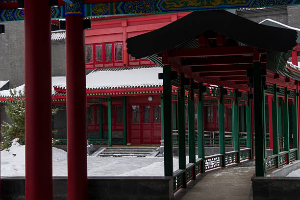 A striking architectural structure reveals vibrant colors contrasted against a snowy backdrop. Traditional Chinese elements are prominently featured, emphasizing the elegance of the design.