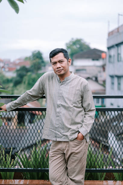 istock Thoughtful man leaning on terrace railing overlooking cityscape view 2201273832