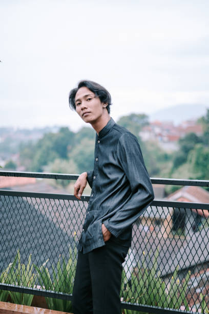 istock Contemplative asian man posing on a balcony overlooking the landscape 2201273833