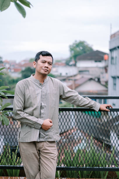 istock Thoughtful man stands on a balcony looking confidently at the horizon 2201273834