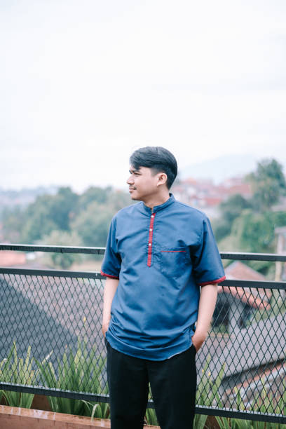 istock Thoughtful young man in blue kurta contemplates the scenic panorama 2201275346