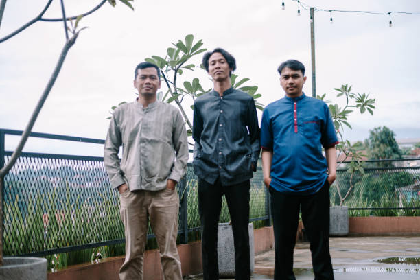 istock Three Indonesian men standing outdoors in traditional batik shirts 2201279110